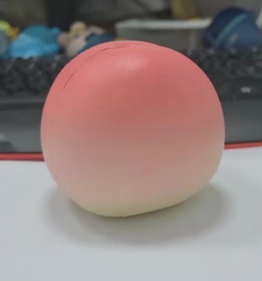 ピンクからクリーム色へグラデーションする桃型スクイーズ
